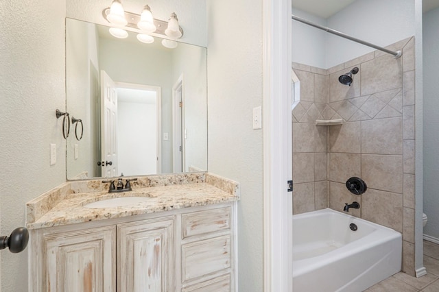 bathroom with vanity, tile patterned flooring, and tiled shower / bath