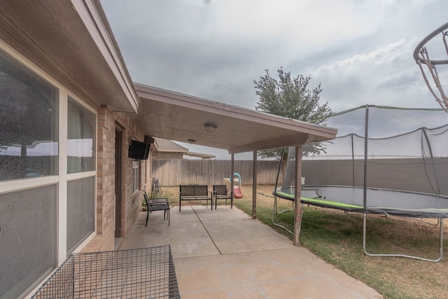 view of patio with a fenced backyard and a trampoline