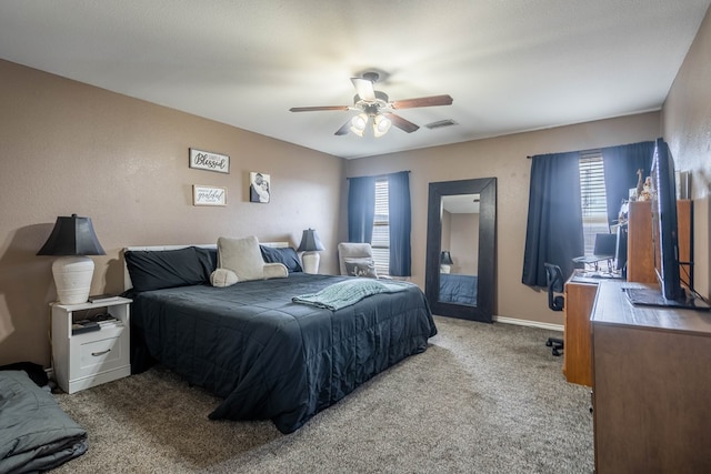 carpeted bedroom with visible vents, a ceiling fan, and baseboards