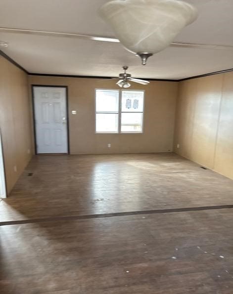 empty room featuring ceiling fan and crown molding