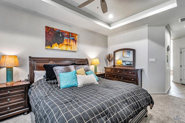 bedroom featuring crown molding, visible vents, a tray ceiling, baseboards, and carpet floors