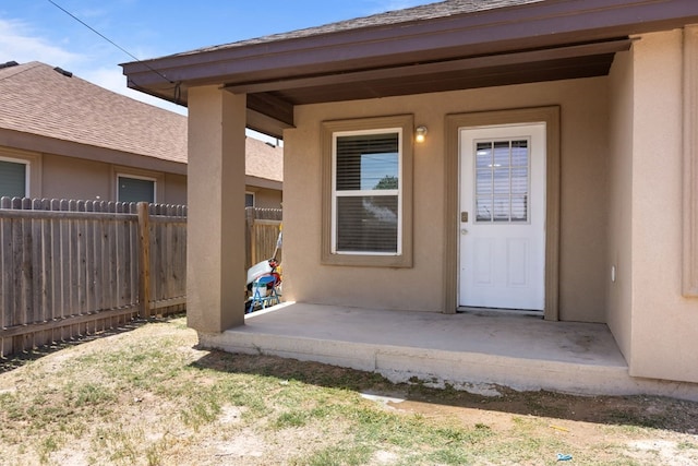 1004 Jefferson St, Odessa, TX 79761 - property entrance featuring fence, stucco siding, roof with shingles, and a patio area