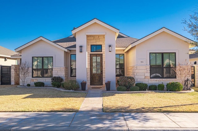 view of front of home featuring a front lawn, stone siding, stucco siding, and a shingled roof