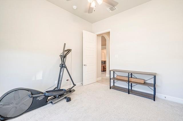 exercise room featuring carpet flooring, ceiling fan, visible vents, baseboards, and arched walkways