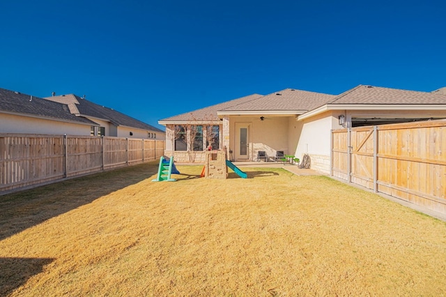 rear view of house with a patio, a shingled roof, ceiling fan, stucco siding, and a fenced backyard
