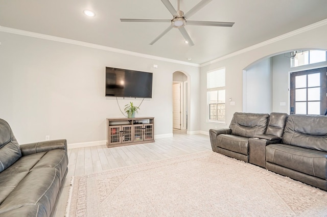 living room with wood finished floors, a ceiling fan, baseboards, and arched walkways