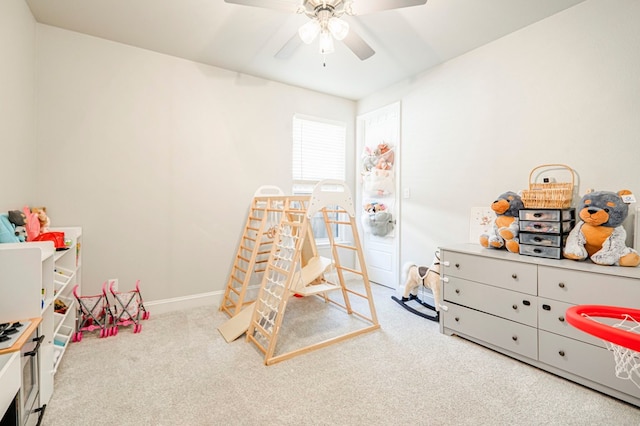 playroom with a ceiling fan, carpet flooring, and baseboards