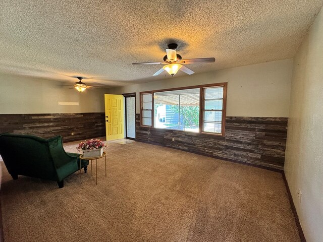 2203 40th St, Snyder, TX 79549 - sitting room featuring carpet, a ceiling fan, a wainscoted wall, a textured ceiling, and wooden walls