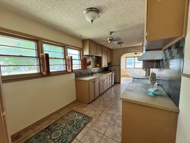 2203 40th St, Snyder, TX 79549 - kitchen with a sink, a ceiling fan, light tile patterned floors, arched walkways, and a textured ceiling