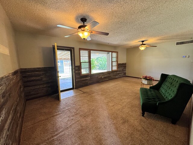 2203 40th St, Snyder, TX 79549 - sitting room featuring a ceiling fan, carpet flooring, a textured ceiling, and wainscoting