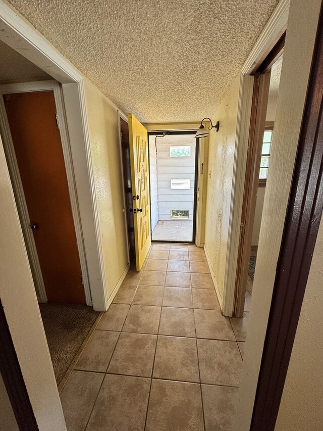 2203 40th St, Snyder, TX 79549 - corridor with a textured ceiling, light tile patterned floors, plenty of natural light, and baseboards