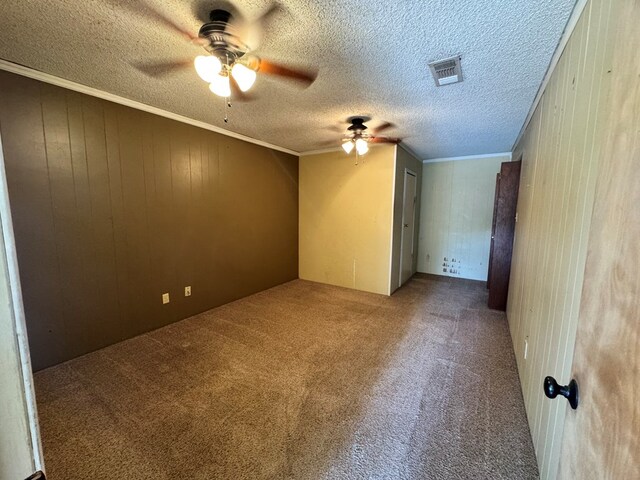 2203 40th St, Snyder, TX 79549 - unfurnished room with a ceiling fan, carpet, wooden walls, a textured ceiling, and crown molding