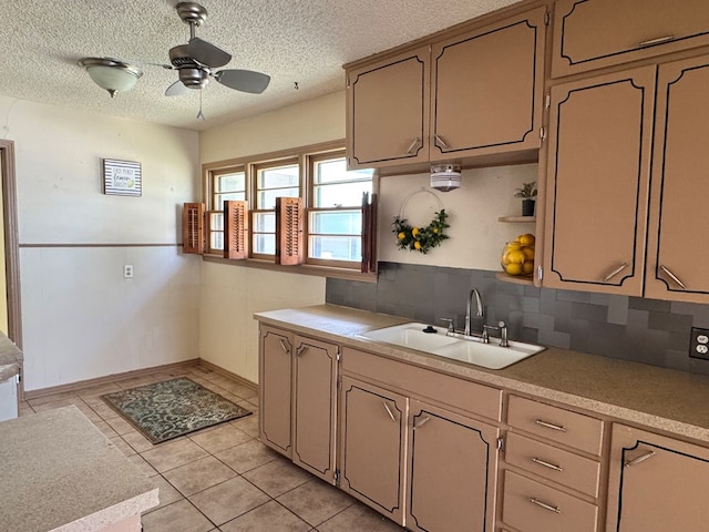 2203 40th St, Snyder, TX 79549 - kitchen with a sink, a ceiling fan, backsplash, light countertops, and a textured ceiling