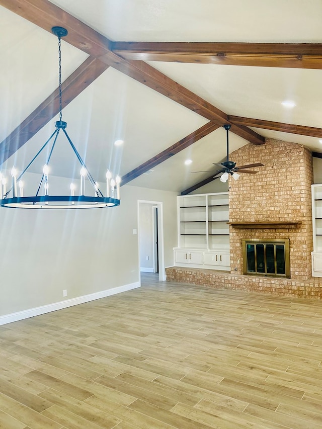 unfurnished living room with lofted ceiling with beams, ceiling fan with notable chandelier, built in shelves, a fireplace, and wood-type flooring