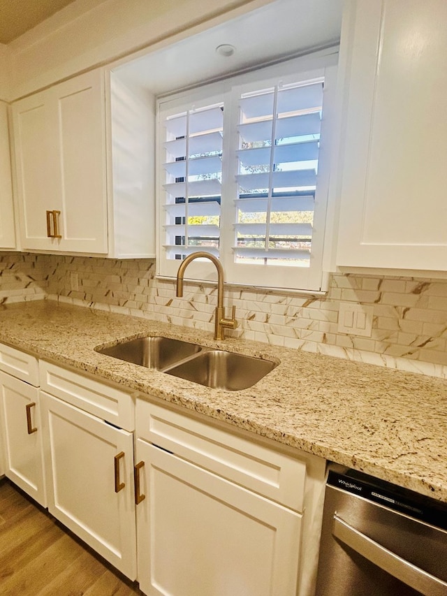 kitchen with hardwood / wood-style floors, dishwasher, white cabinets, and sink