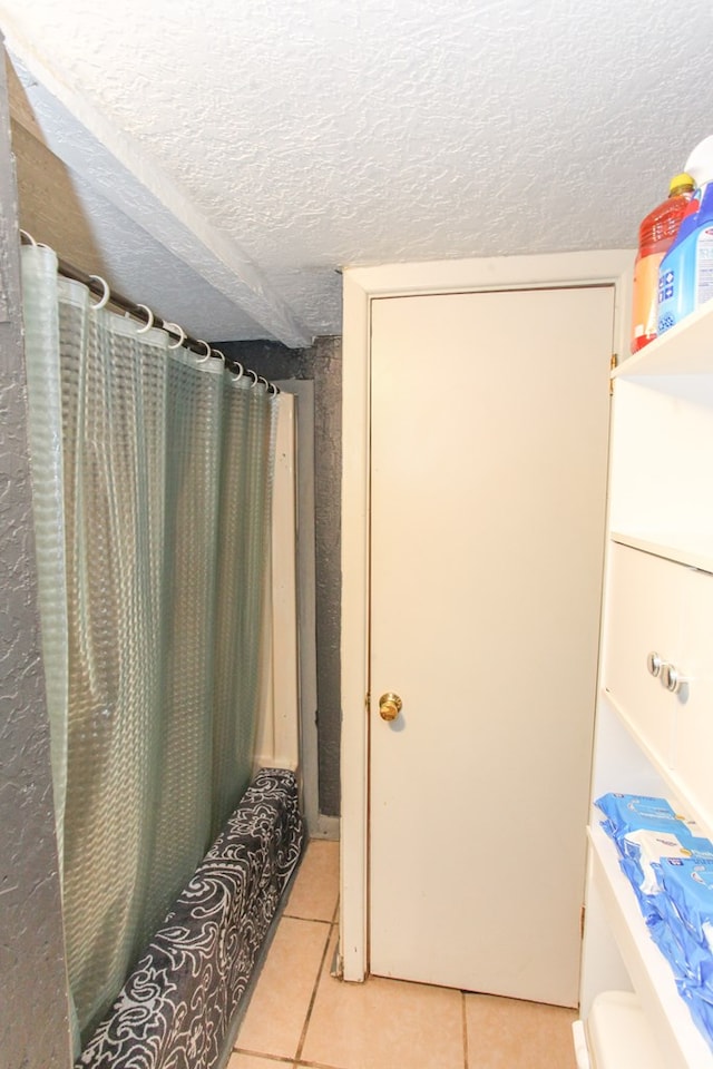 2101 Grace St, Big Spring, TX 79720 - full bath with a textured ceiling, tile patterned flooring, and a shower with curtain