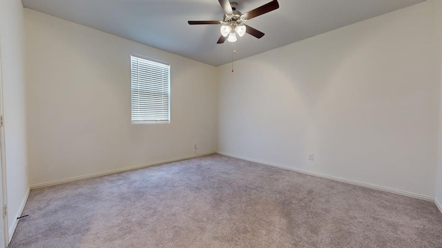 carpeted empty room with a ceiling fan and baseboards