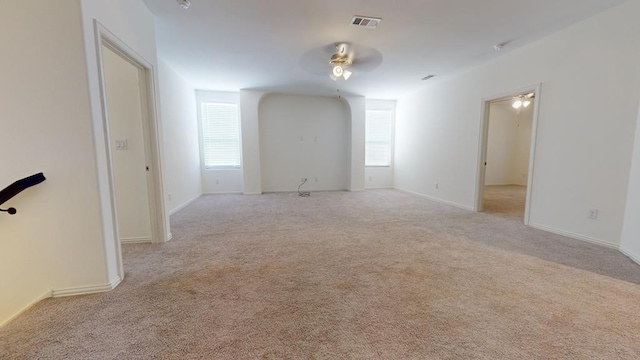 unfurnished room with a ceiling fan, carpet flooring, baseboards, and visible vents