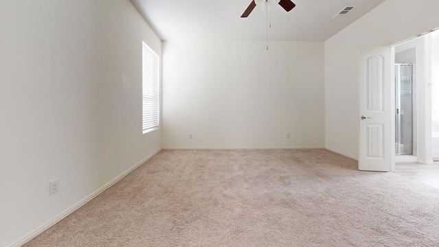 unfurnished room featuring visible vents, baseboards, light colored carpet, and a ceiling fan