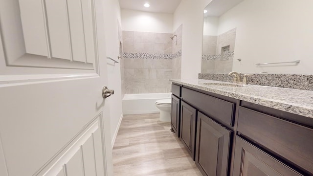 full bathroom featuring toilet,  shower combination, wood finished floors, and vanity