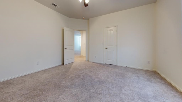 unfurnished room featuring baseboards, light colored carpet, visible vents, and ceiling fan