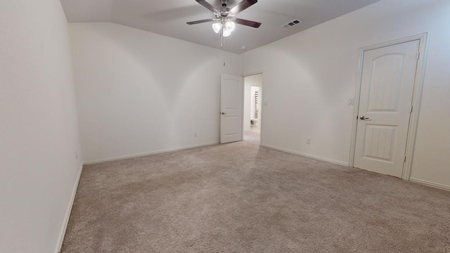 carpeted empty room with visible vents, baseboards, lofted ceiling, and a ceiling fan