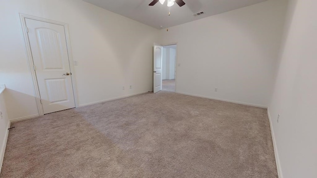 empty room featuring baseboards, visible vents, a ceiling fan, and carpet