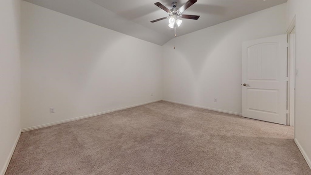 spare room featuring baseboards, lofted ceiling, ceiling fan, and carpet flooring