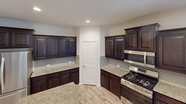 kitchen with dark brown cabinetry, decorative backsplash, and stainless steel appliances