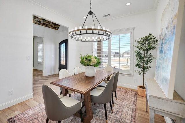 dining area with arched walkways, visible vents, ornamental molding, light wood-style floors, and baseboards