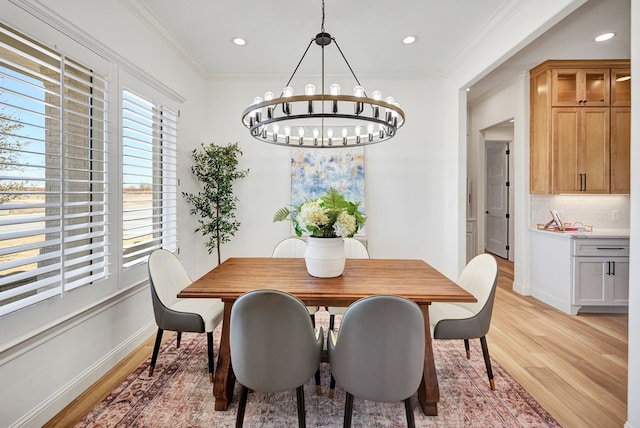 dining area with baseboards, light wood-style flooring, an inviting chandelier, crown molding, and recessed lighting