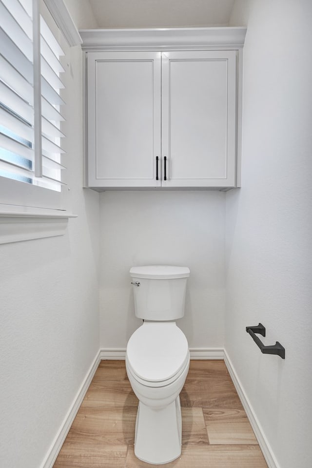 bathroom featuring baseboards, toilet, and wood finished floors