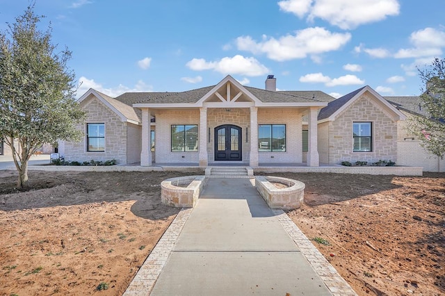 view of front of house with an outdoor fire pit and french doors