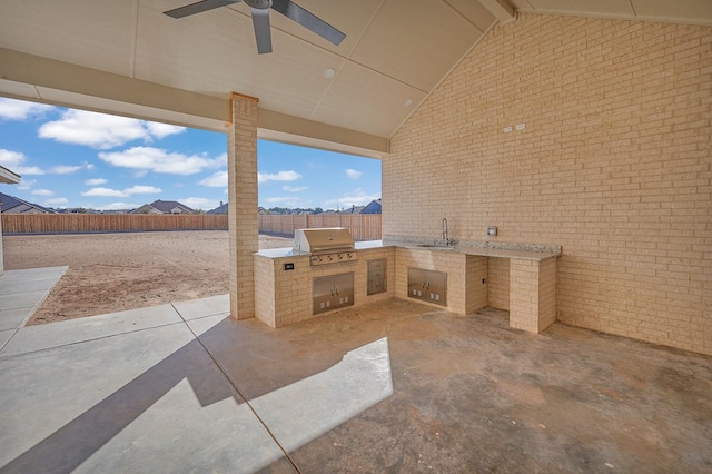 view of patio / terrace with area for grilling, a sink, a ceiling fan, fence, and exterior kitchen