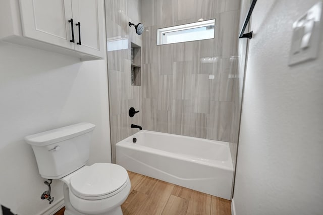 bathroom featuring bathing tub / shower combination, toilet, and wood finished floors