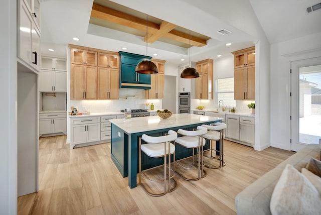 kitchen with glass insert cabinets, pendant lighting, visible vents, and a kitchen island