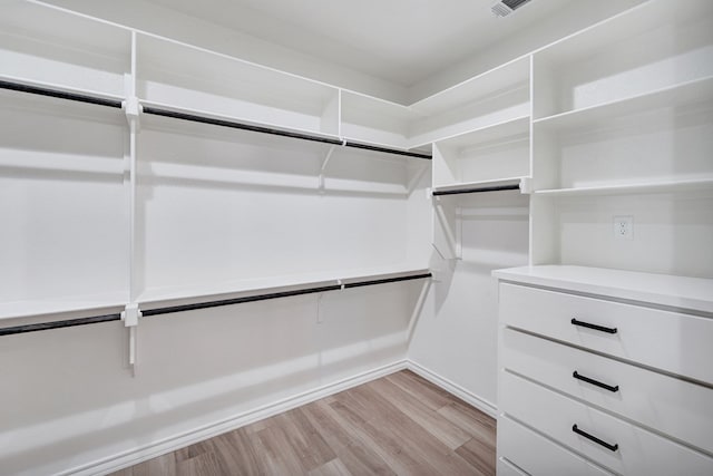 walk in closet with light wood finished floors and visible vents