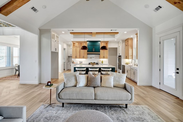 living area featuring light wood finished floors, baseboards, and visible vents