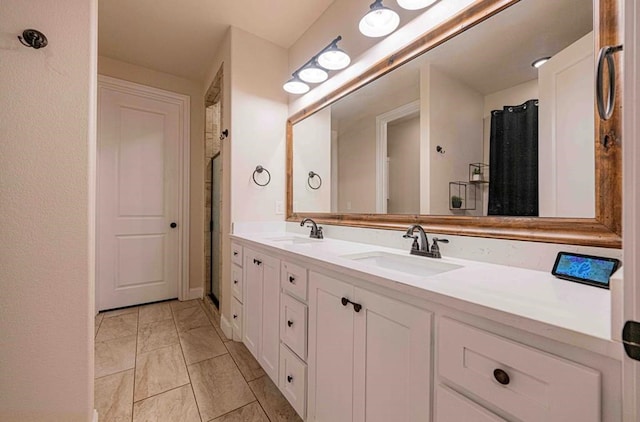 bathroom with double vanity, a shower with curtain, marble finish floor, and a sink