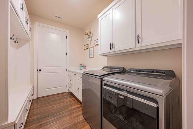 1202 Stonefield Dr, Midland, TX 79706 - laundry room featuring separate washer and dryer, dark wood-style flooring, and cabinet space