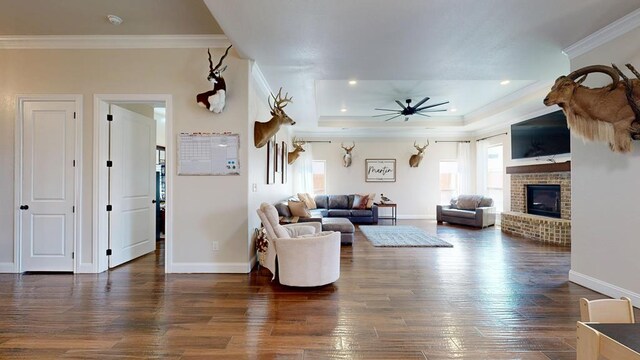 1202 Stonefield Dr, Midland, TX 79706 - living area featuring plenty of natural light, ornamental molding, a fireplace, wood finished floors, and a tray ceiling