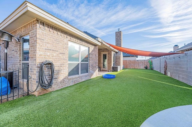 view of yard featuring a fenced backyard and central AC unit