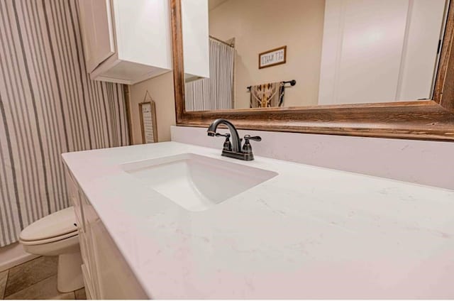 full bath featuring vanity and toilet