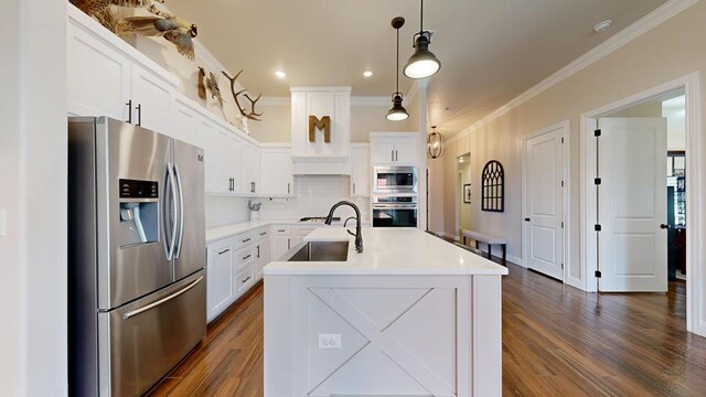 1202 Stonefield Dr, Midland, TX 79706 - kitchen with stainless steel appliances, a sink, ornamental molding, dark wood finished floors, and white cabinets