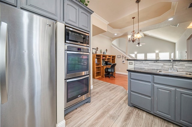 kitchen with stainless steel appliances, gray cabinetry, light hardwood / wood-style flooring, and sink