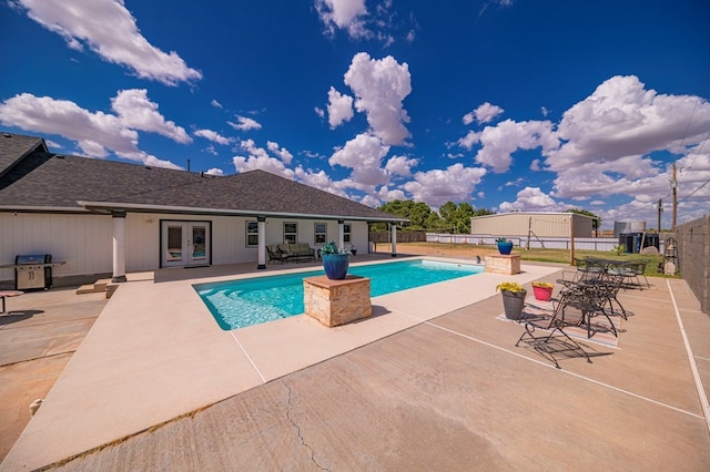 view of swimming pool with a grill, french doors, and a patio