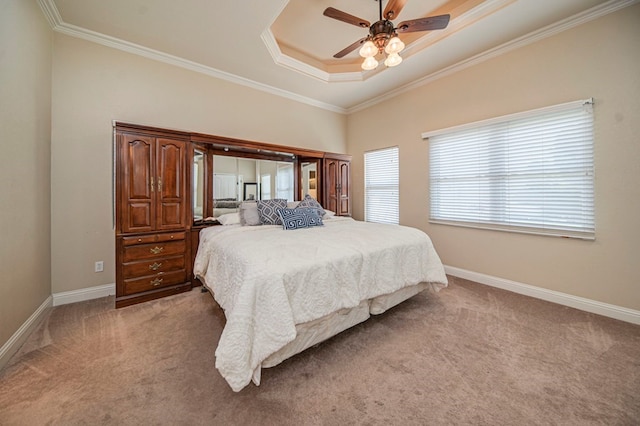 bedroom featuring ceiling fan, light carpet, crown molding, and a tray ceiling