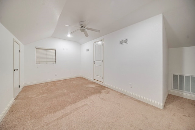 interior space featuring ceiling fan, light colored carpet, and lofted ceiling