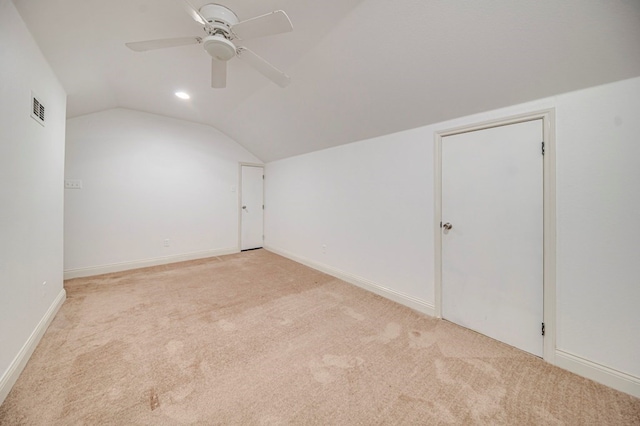 additional living space featuring lofted ceiling, light carpet, and ceiling fan