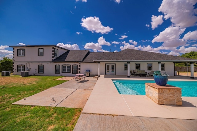 view of swimming pool featuring central AC, a lawn, and a patio